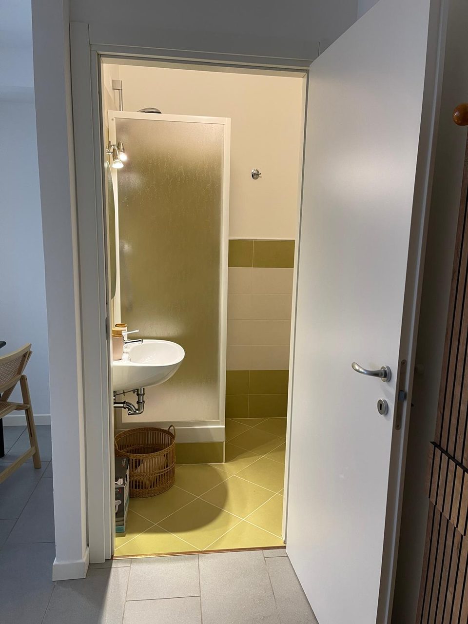 Bagno di Mimi's House con box doccia, lavabo e piastrelle color oliva