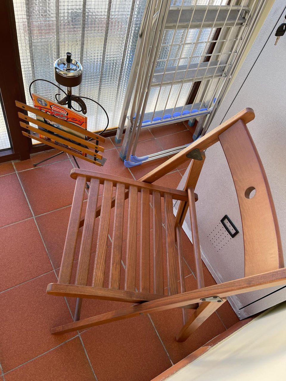 Balcone di Mimi's House con sedia pieghevole in legno e stendibiancheria