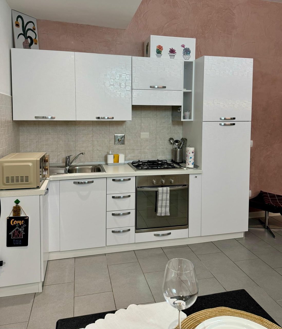 Cucina attrezzata di Mimi's House con forno, piano cottura a gas, microonde e stoviglie