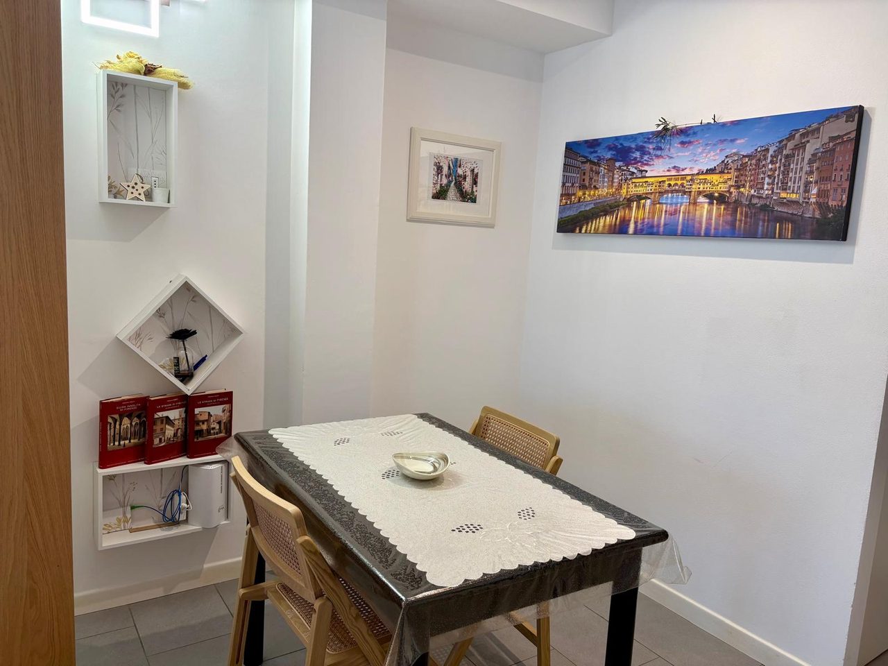 Angolo pranzo con tavolo, sedie in paglia di Vienna e stampa del Ponte Vecchio